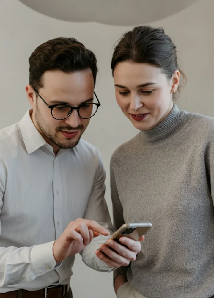 Duas pessoas olhando juntas a tela de um celular